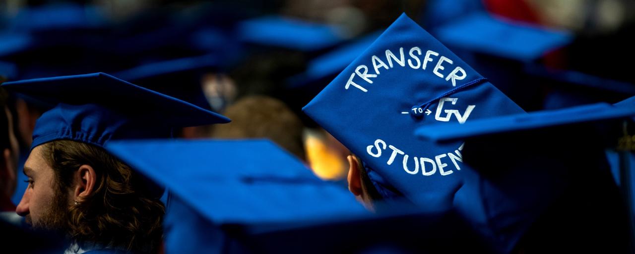 GVSU students at graduation with a cap that says Transfer to GV Student
